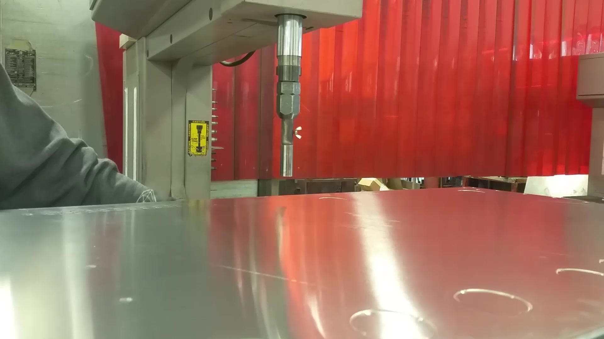 A hardware insertion press over an aluminum panel