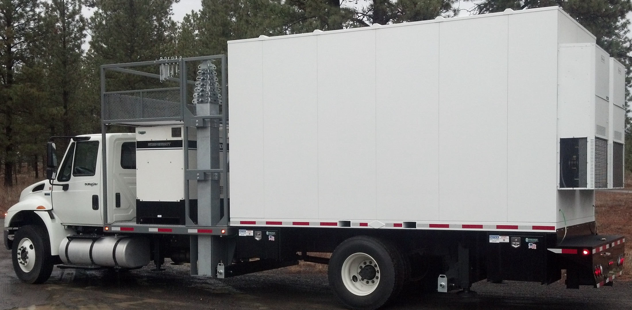 A Premier shelter mounted on the bed of a white truck