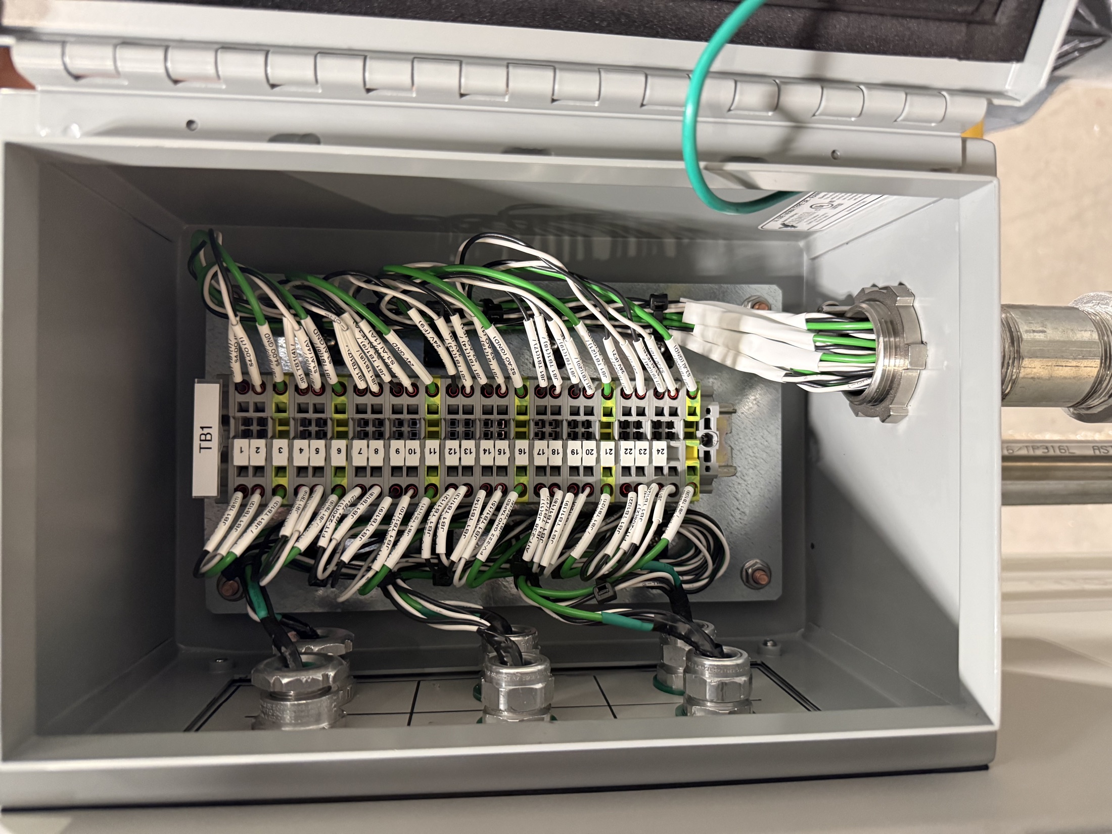 An open junction box with rows of terminal blocks and wiring