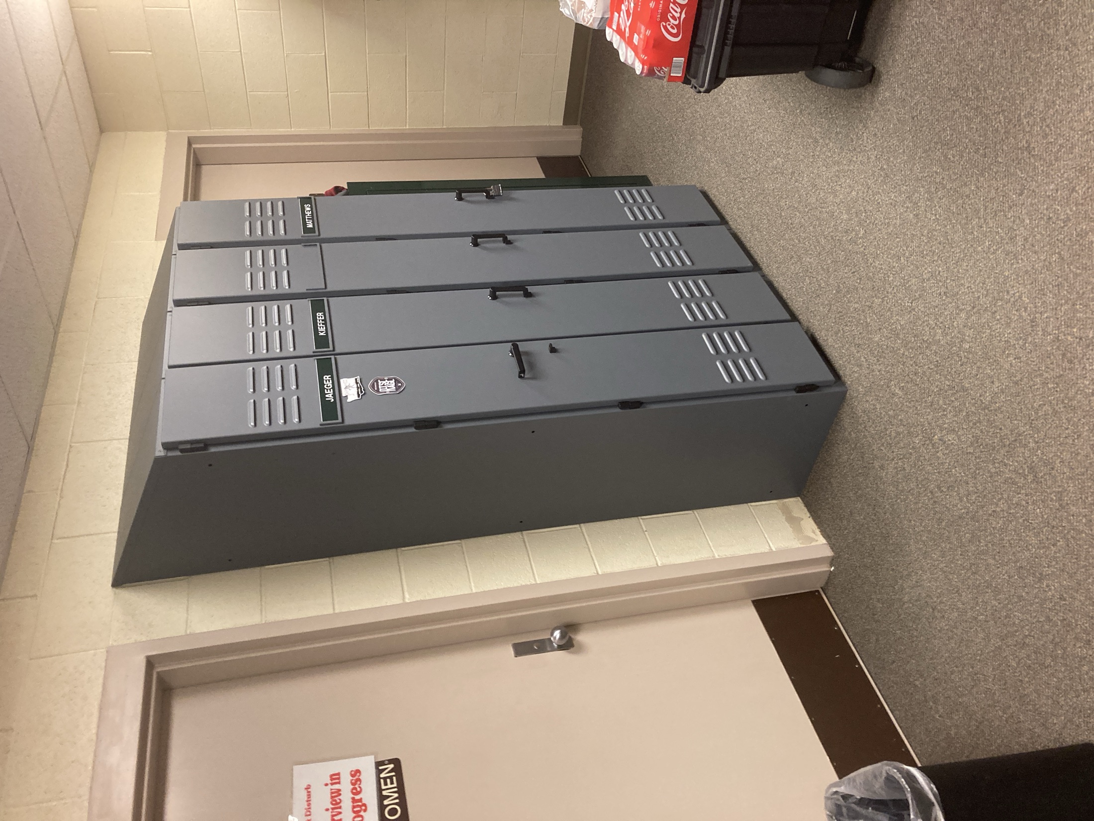 A bank of grey powder-coated lockers installed in a hallway
