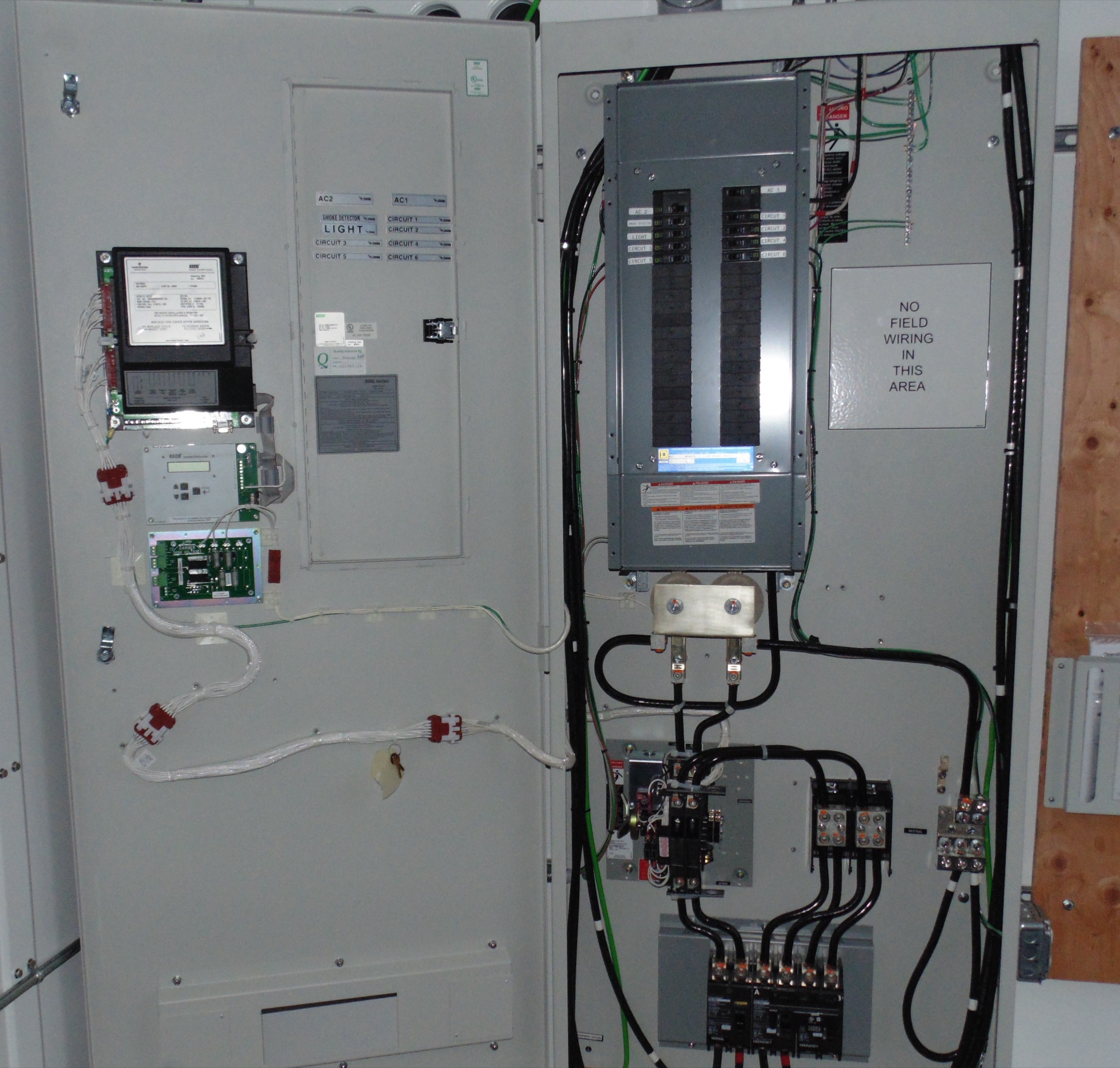 An open power panel enclosure with breakers, a meter and wiring