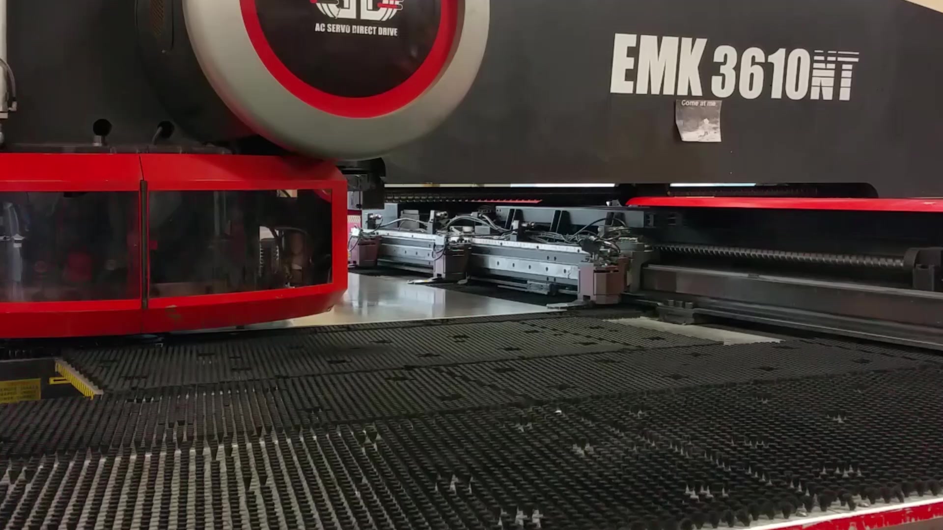 An Amada EMK3610NT turret punch working a sheet