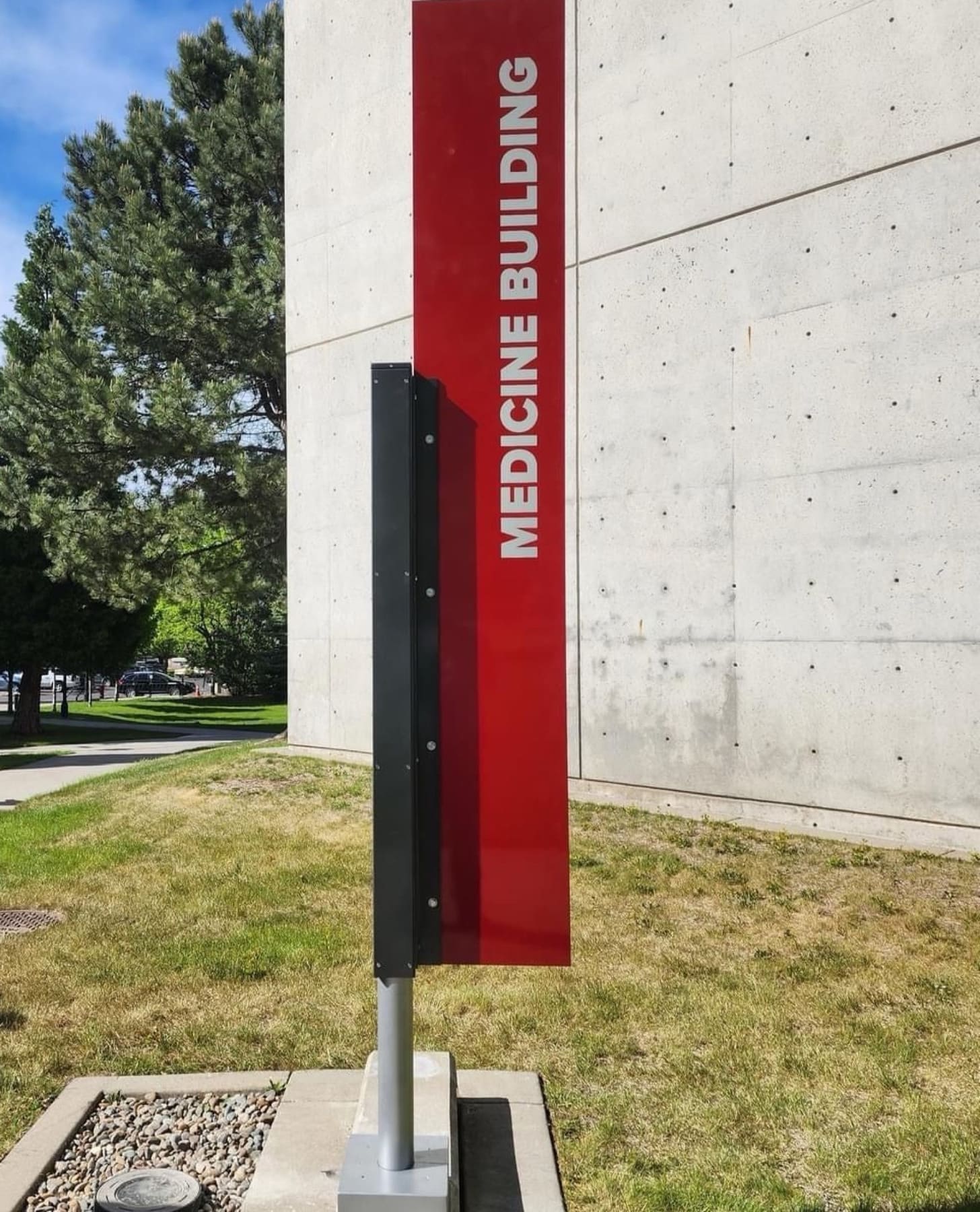 A tall powder-coated metal sign outside a building